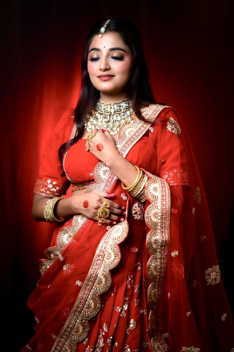 Punjabi bride in scalloped red dupatta, dramatic light — Navi Mumbai
